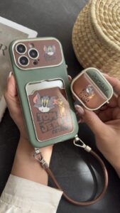 قاب موبایل آیفون تام و جری سبز و قهوه ای جاکارتی دار + بندست - تصویر 2