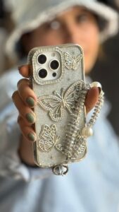 قاب موبایل ( آیفون - سامسونگ ) پروانه آموره نگین دار برجسته شاینی + بندست - تصویر 2